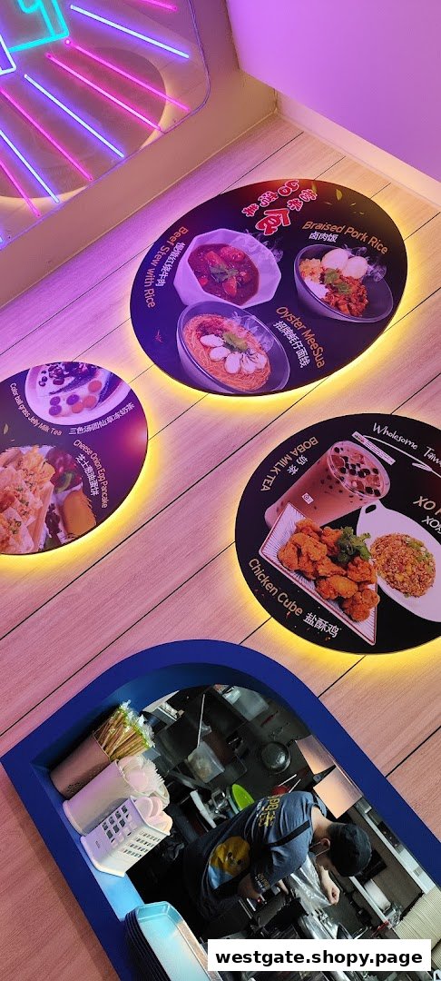 Illuminated circular displays showcasing popular Taiwanese dishes and drinks, with a glimpse of the kitchen.