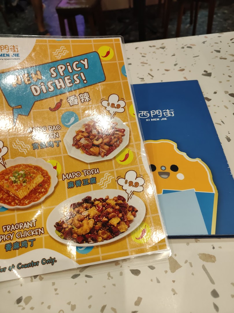 A menu highlighting new spicy dishes from Xi Men Jie, featuring Gong Bao Chicken, Mapo Tofu, and Fragrant Spicy Chicken.