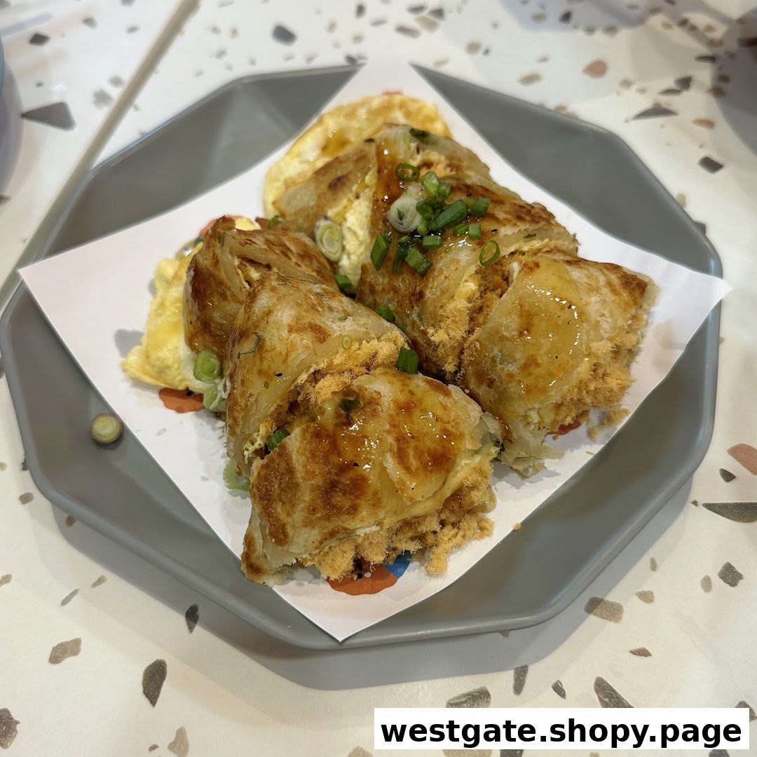 A close-up of a delicious Taiwanese egg pancake (dan bing) with pork floss and a savory sauce.