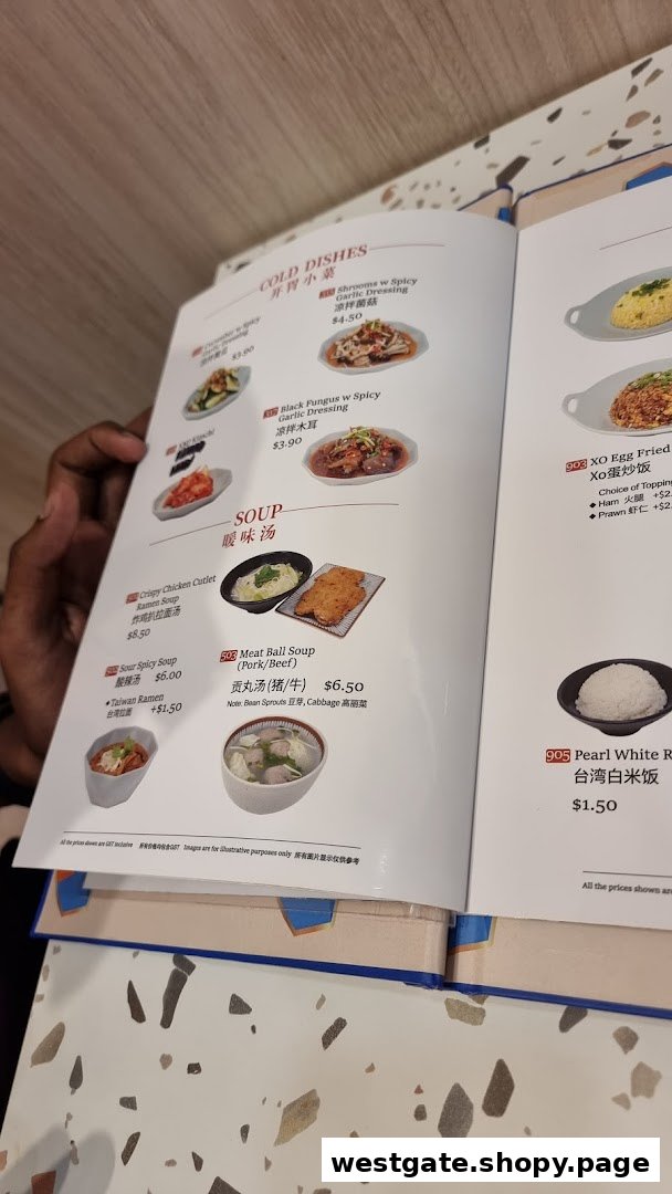 A person's hand holding open a menu displaying various Taiwanese cold dishes, soups, and rice options.