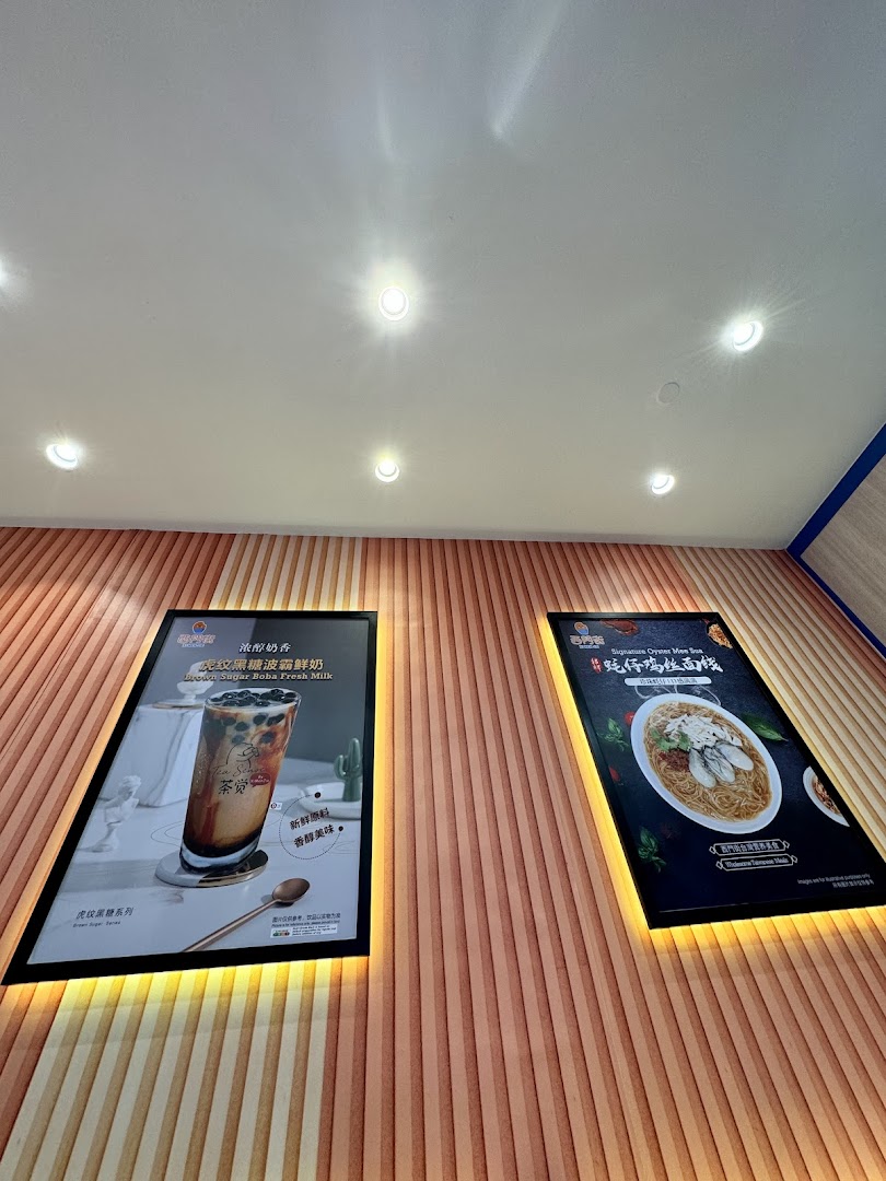 Two illuminated posters on a textured wall, showcasing brown sugar boba milk and oyster mee sua.