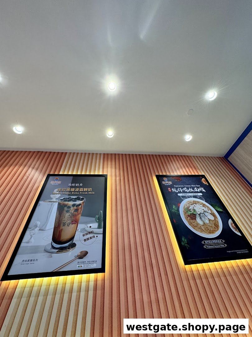 Two illuminated posters on a textured wall, showcasing brown sugar boba milk and oyster mee sua.