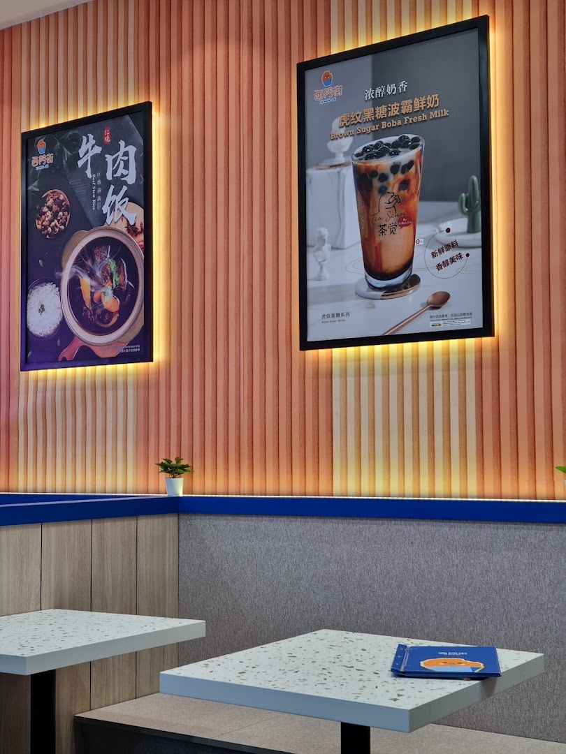 Interior view of Xi Men Jie featuring illuminated posters for beef rice and brown sugar boba fresh milk.