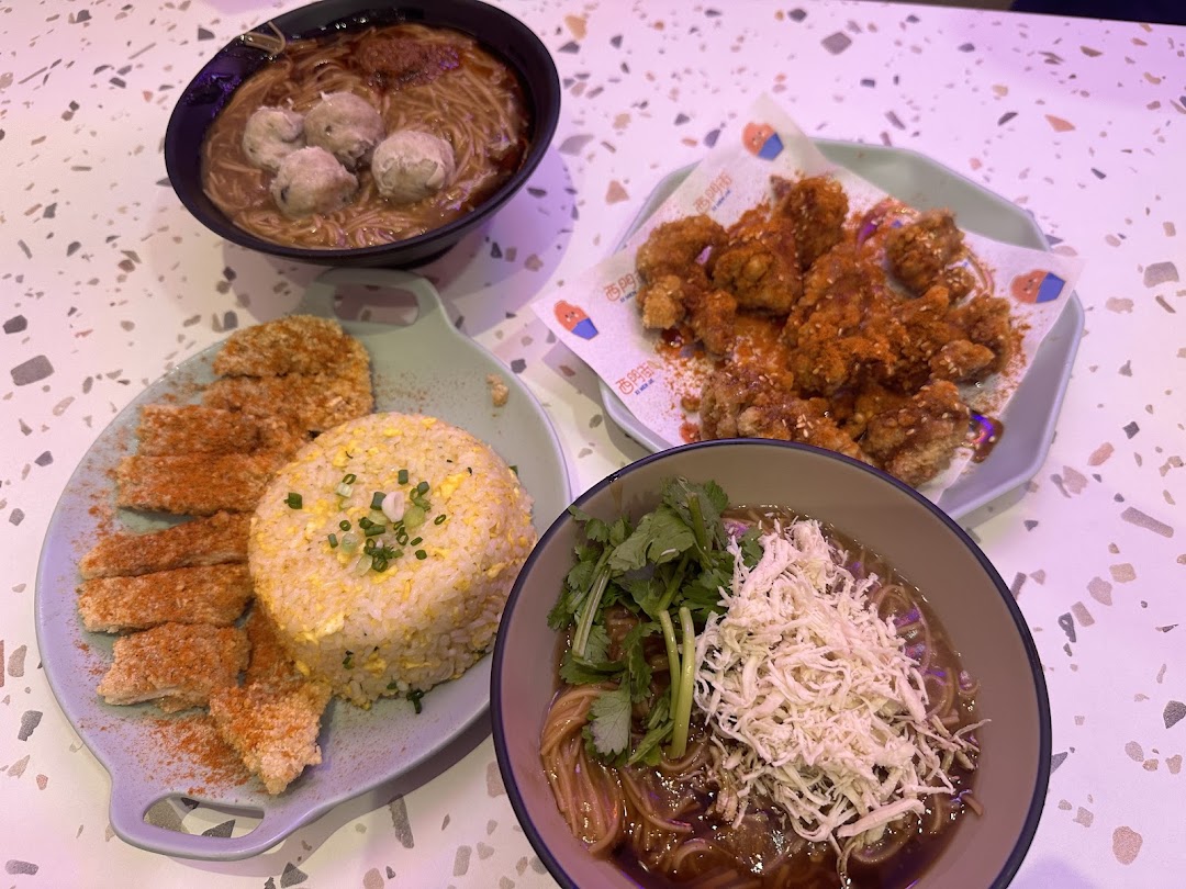 A vibrant spread of authentic Taiwanese dishes including fried chicken, noodles, and pork chop with fried rice.