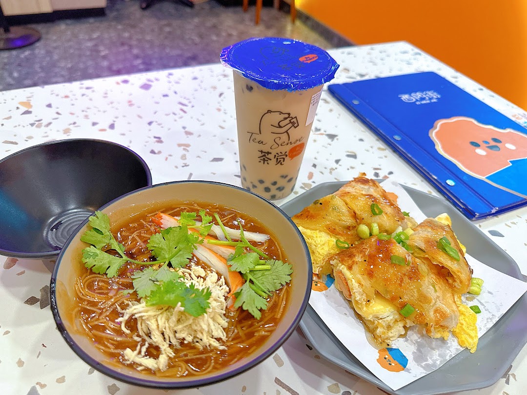 A delicious spread of Taiwanese vermicelli, savory pancake, and bubble tea on a speckled table.