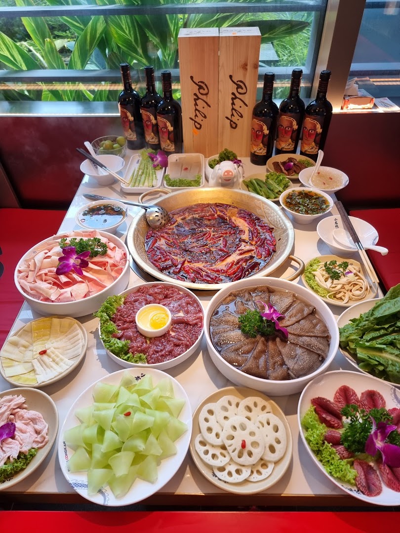 A vibrant hotpot spread with various fresh ingredients and a bubbling spicy broth.