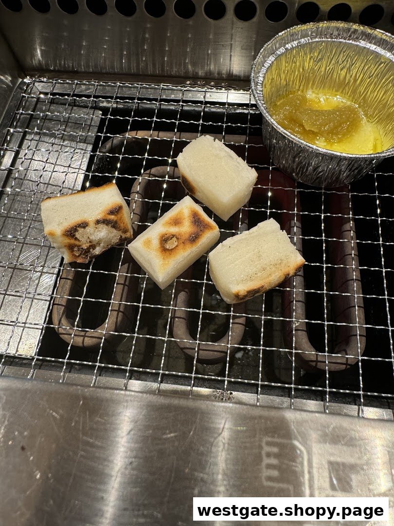 Grilled mochi or rice cakes on a personal yakiniku grill with a dipping sauce.