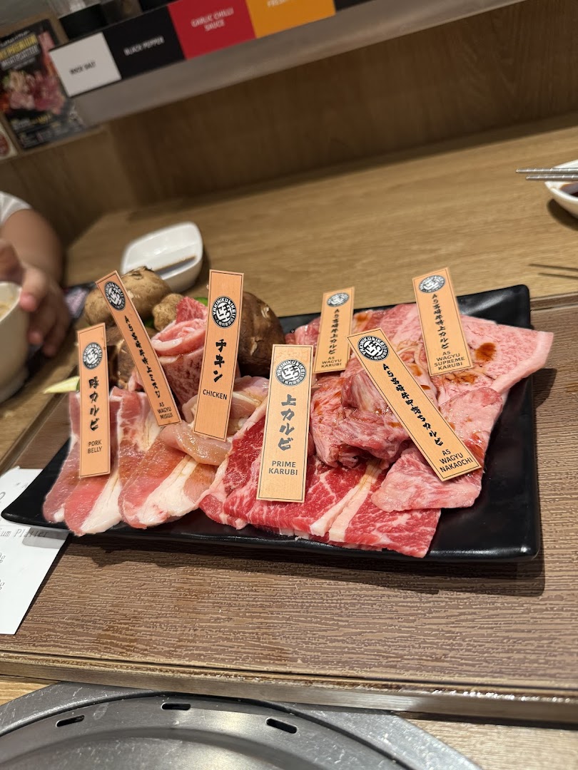 A tempting platter of various raw meats, including wagyu, chicken, and pork belly, ready for grilling.