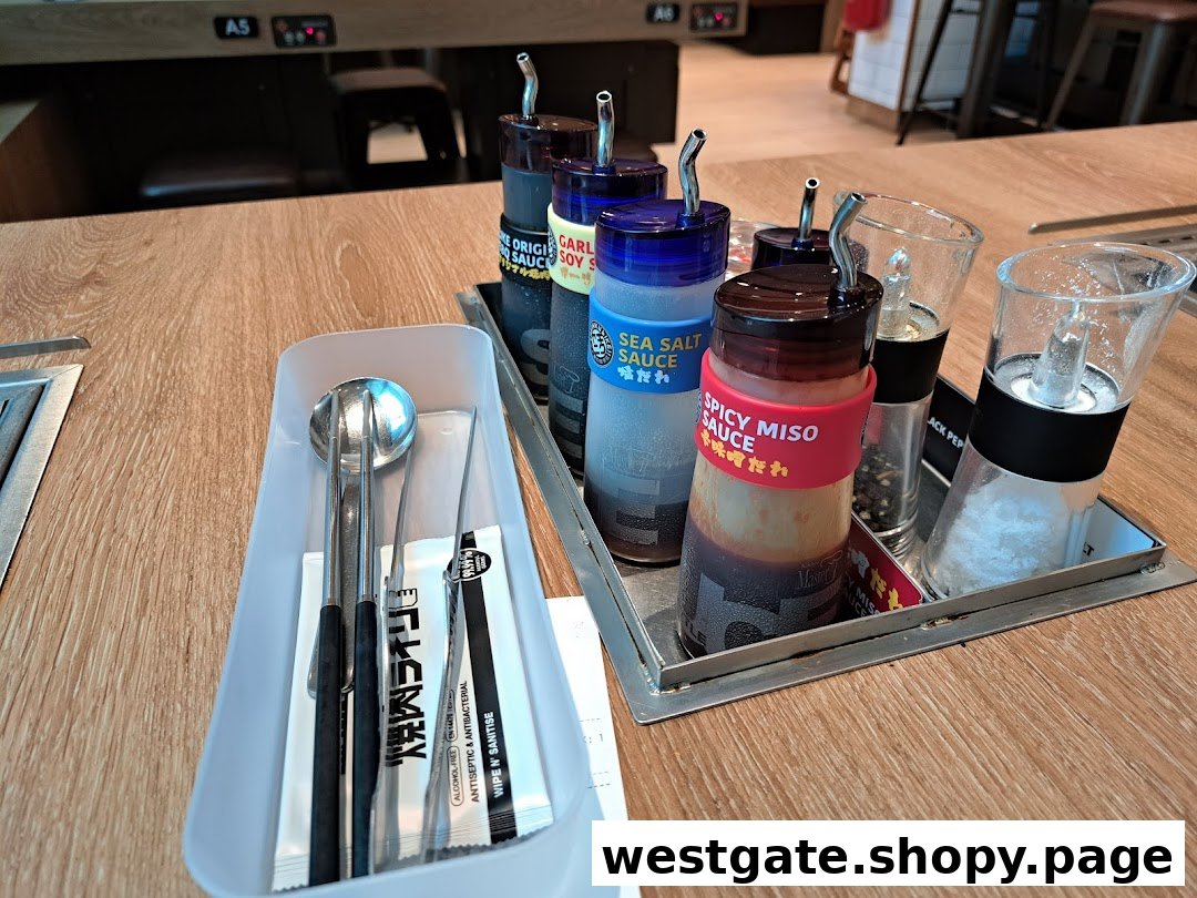 A table setting at Yakiniku Like, featuring various sauces, salt, pepper, and cutlery.