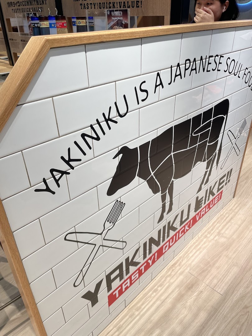 An interior shot of Yakiniku Like, featuring a tiled sign with a cow diagram and brand slogans.