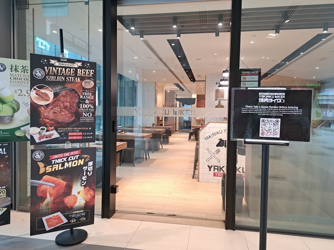 The entrance of Yakiniku Like, featuring promotional posters for vintage beef sirloin and thick-cut salmon.