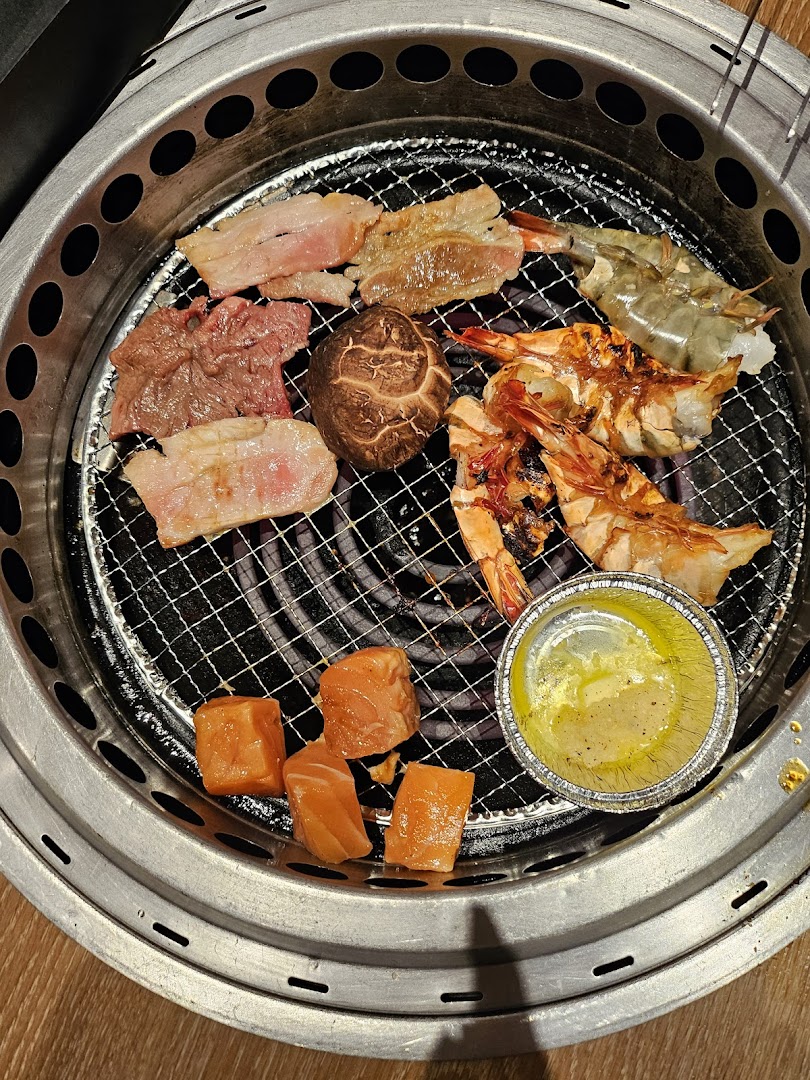 Various meats, seafood, and vegetables grilling on a yakiniku barbecue at Yakiniku Like.