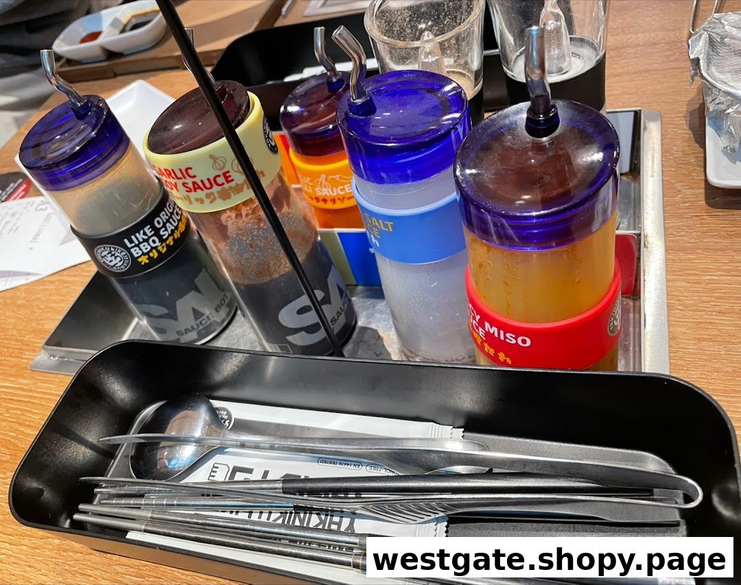 A close-up of various sauces, condiments, and cutlery on a table at Yakiniku Like.