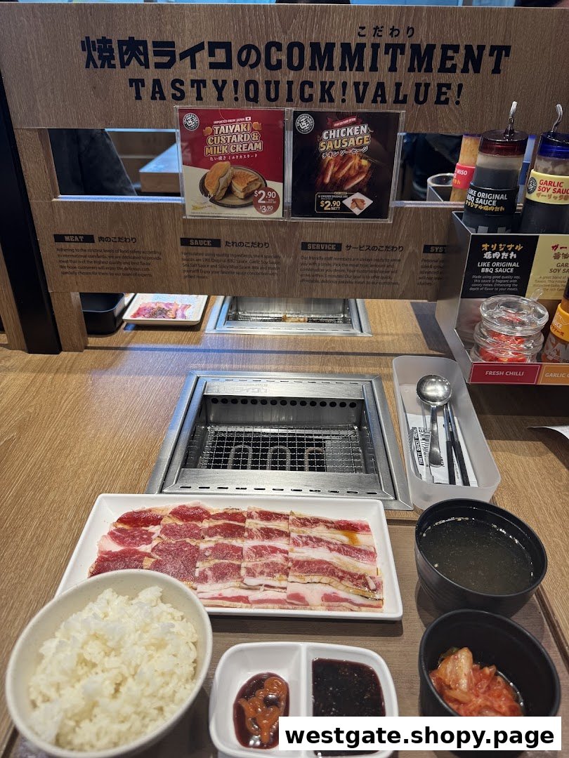 A close-up of a Yakiniku Like dining setup with raw meat, rice, sauces, and a grill.