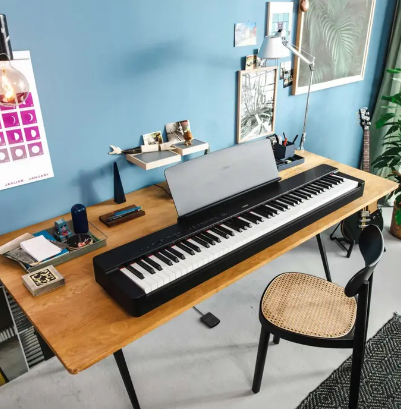 A Yamaha digital piano on a wooden desk in a modern room, ready for music practice.