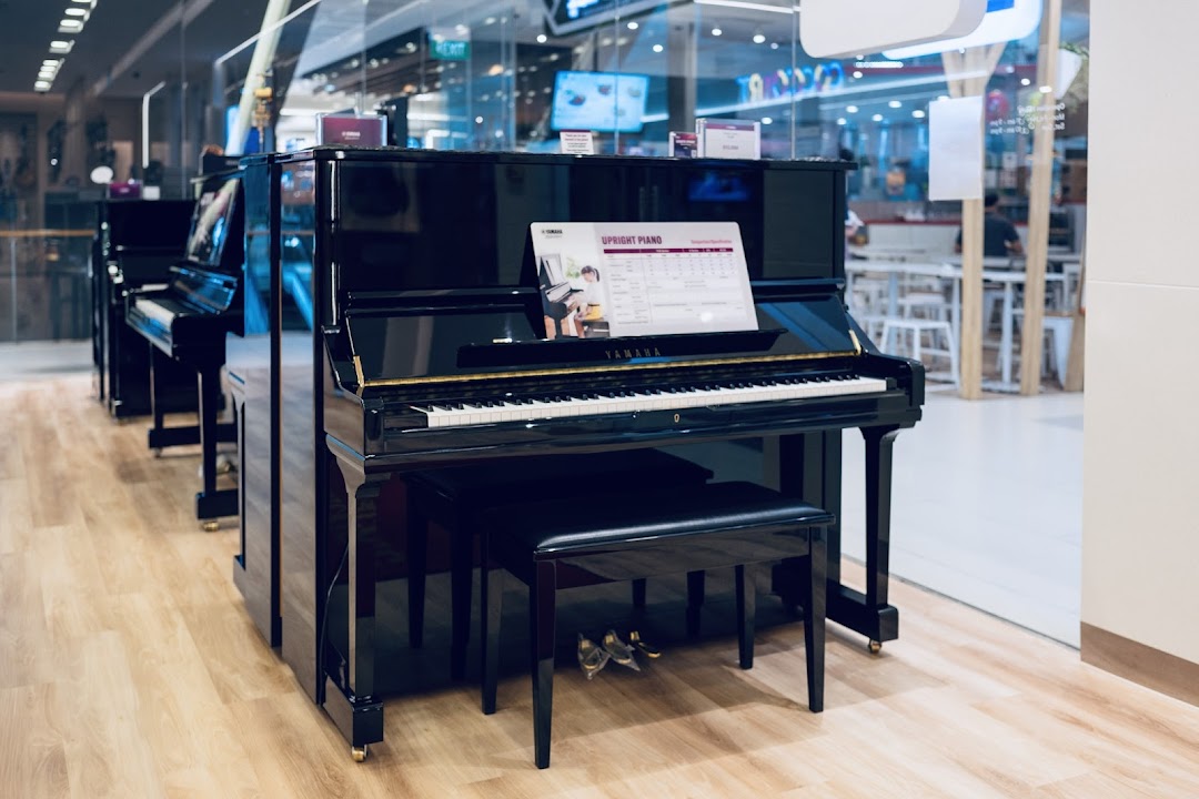 A row of sleek black Yamaha upright pianos displayed in a modern music store.