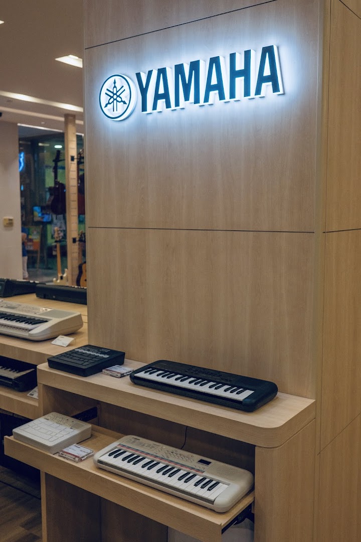 Interior view of Yamaha Music Store displaying various keyboards and the illuminated brand logo.