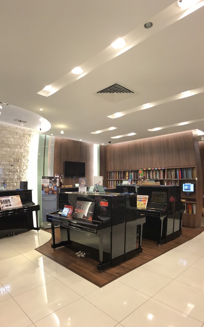 Interior view of a Yamaha Music Store, showcasing pianos, music books, and a welcoming ambiance.