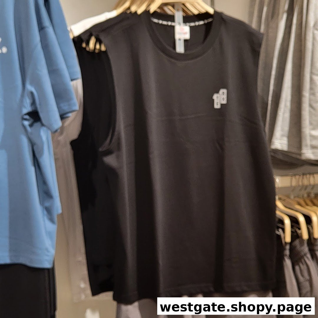 A black sleeveless top with a small white logo, displayed on a hanger in a clothing store.