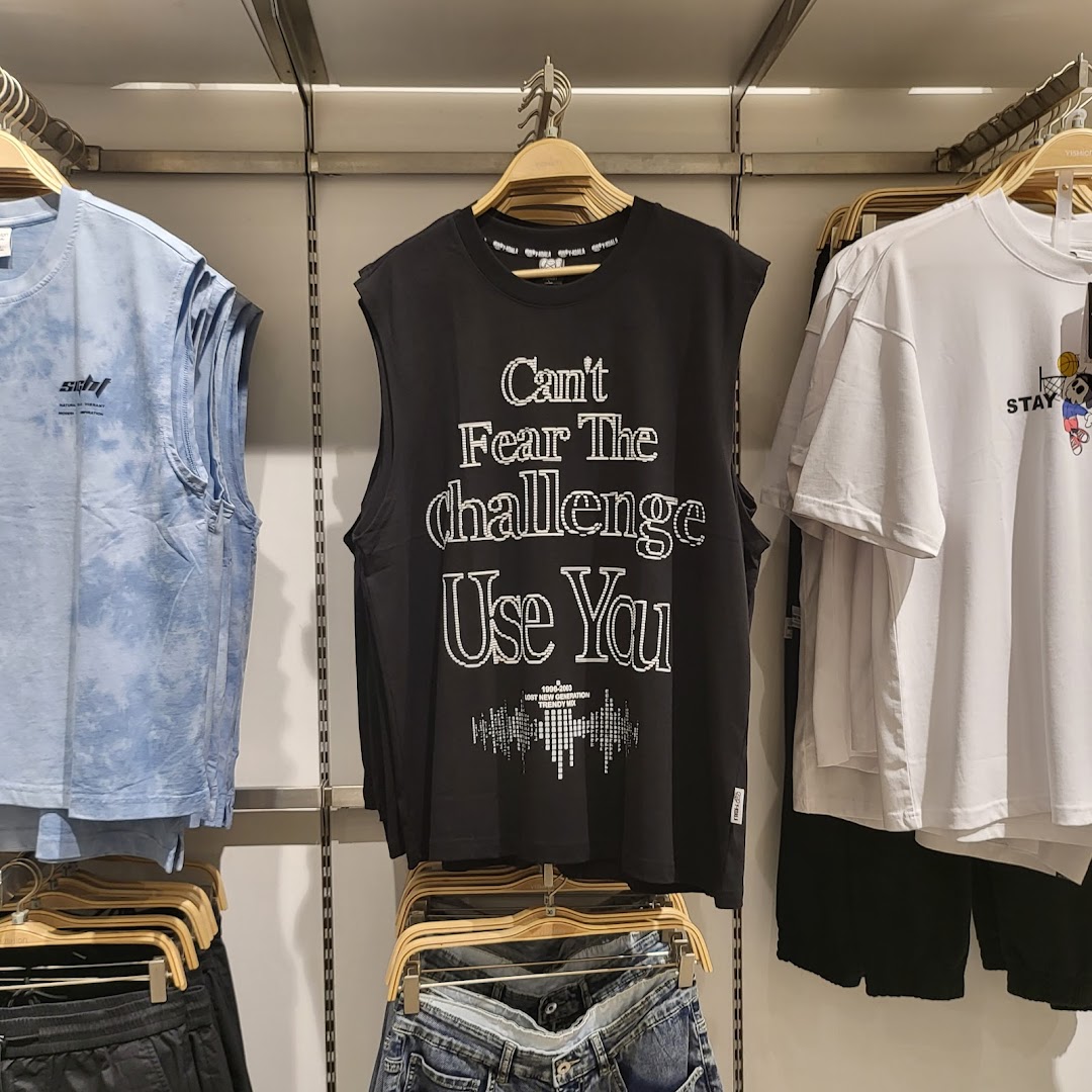 A display of trendy casual wear, including a black graphic tank top and blue tie-dye top.