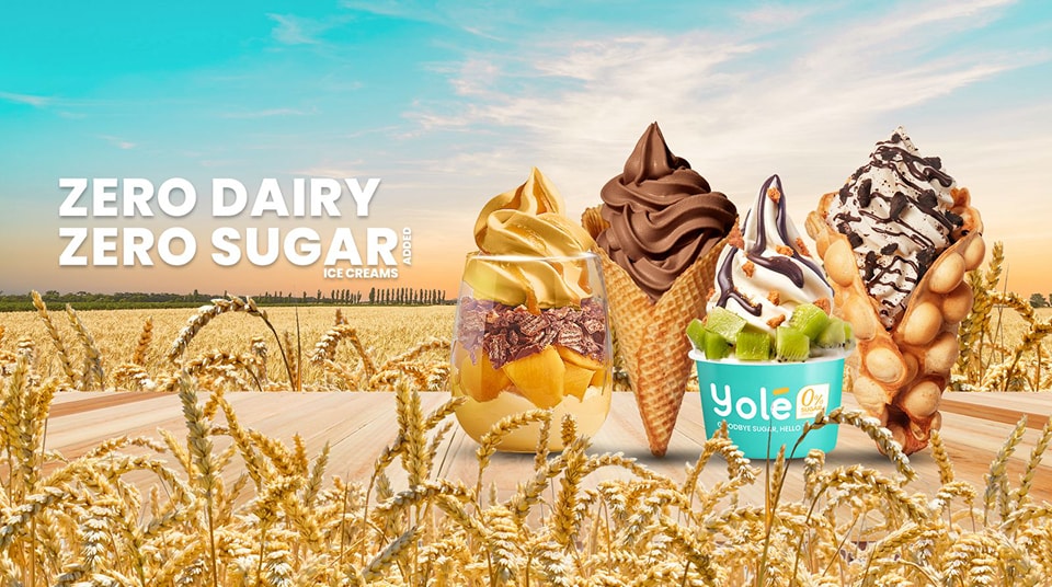 A vibrant image showcasing various Yolé zero dairy, zero sugar ice cream creations amidst a wheat field.