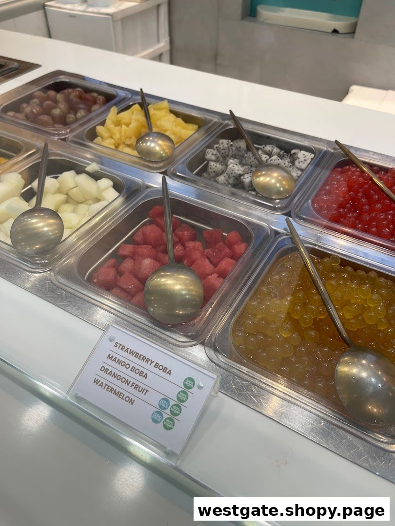 A vibrant display of fresh fruit and boba toppings for frozen yogurt.
