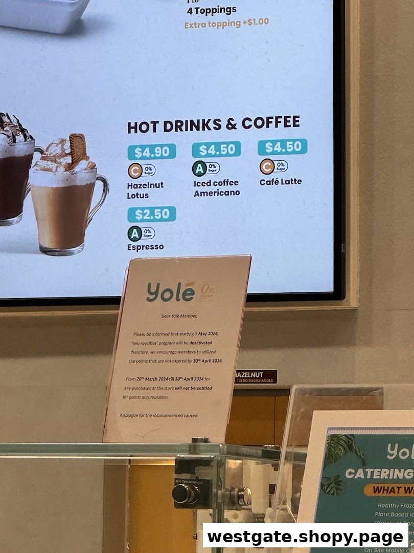 A digital menu board displaying hot drinks and coffee options with prices at Yolé, alongside a loyalty program update.