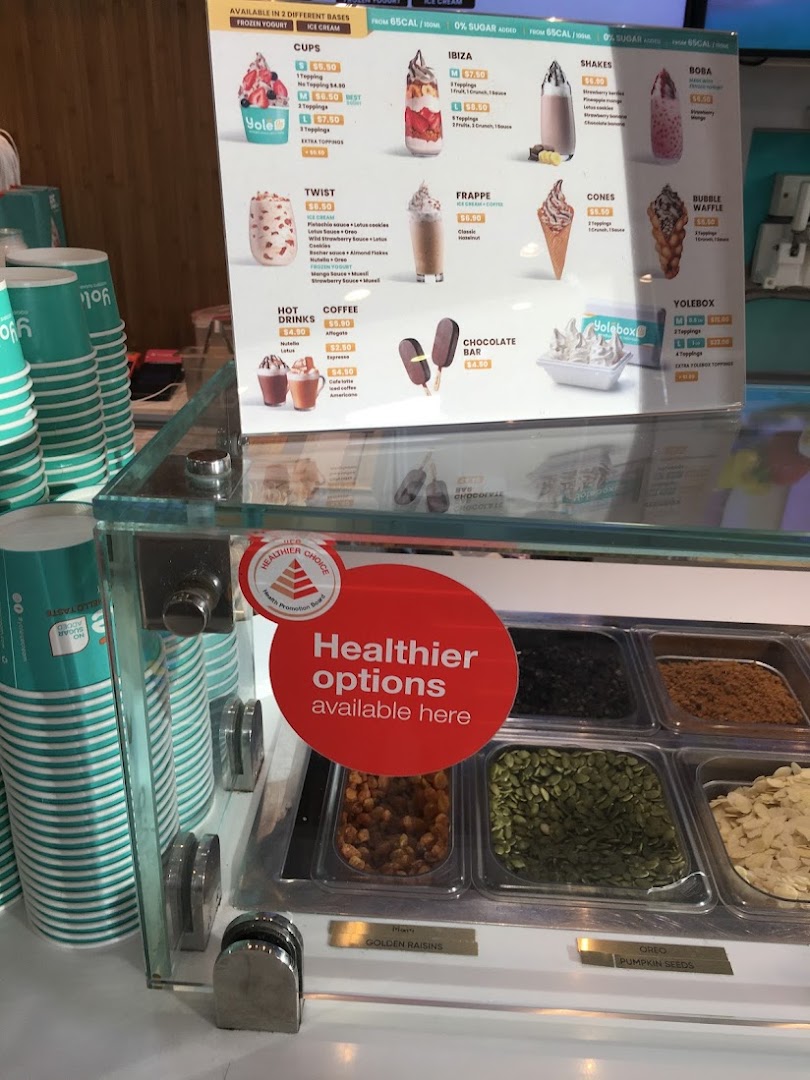 A detailed menu board for Yolé frozen yogurt and desserts, showcasing various cups, shakes, and toppings.