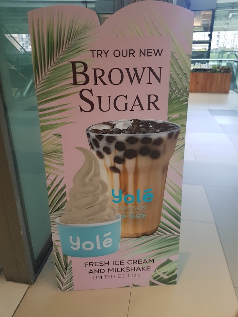 A promotional standee for Yolé featuring new Brown Sugar ice cream and milkshake, with tropical leaf design.
