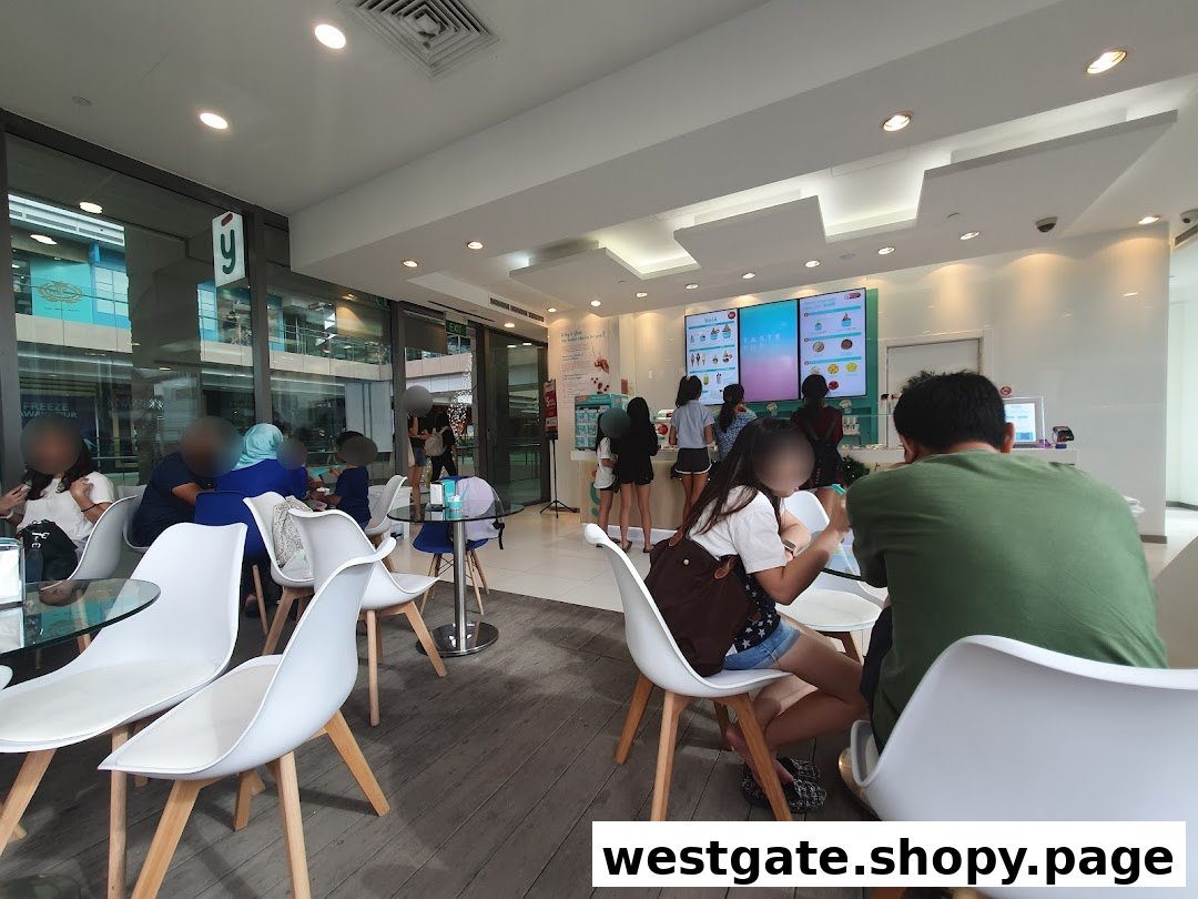 Customers enjoying frozen yogurt in the bright, modern interior of Yolé Westgate, featuring digital menu screens.
