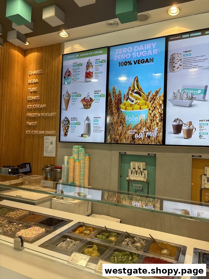 Interior view of Yolé Westgate, showcasing the frozen yogurt counter, toppings, and digital menu boards.