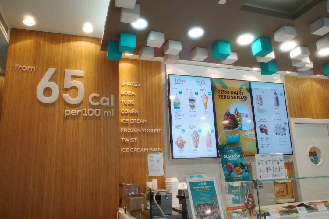 Interior view of Yolé Westgate, showcasing digital menus, counter, and calorie information.