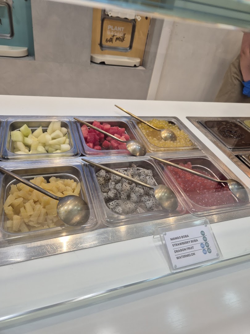 A vibrant display of fresh fruit and boba toppings for frozen yogurt or desserts.