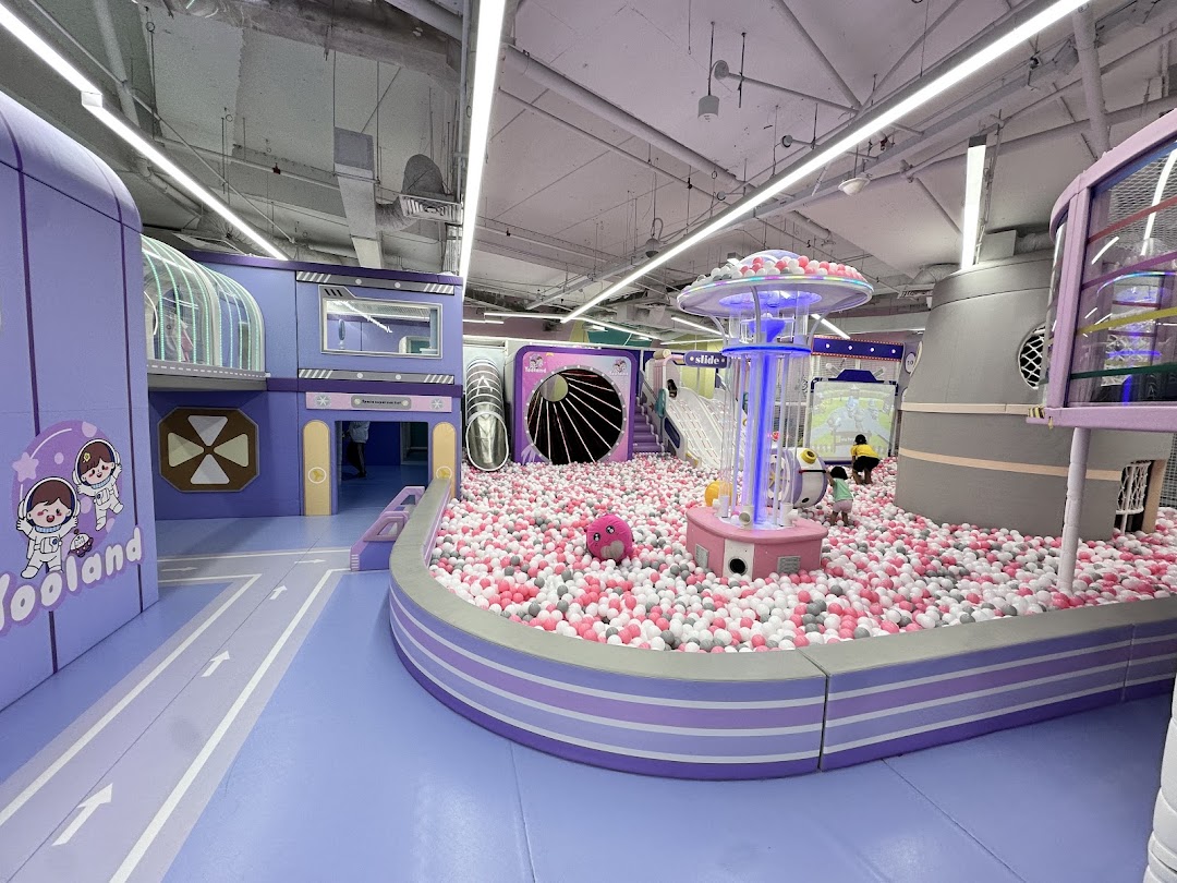 A vibrant indoor play area at Yooland featuring a large ball pit and space-themed structures.
