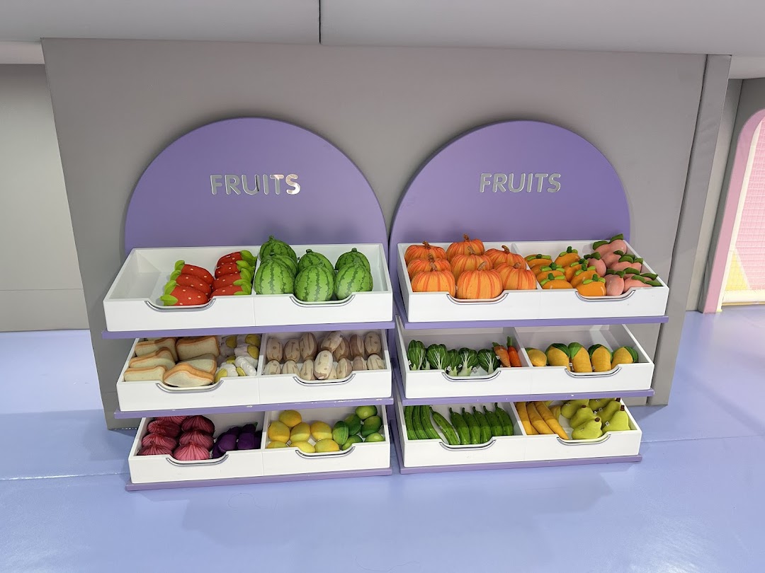 A vibrant display of toy fruits and vegetables on shelves, designed for imaginative play.