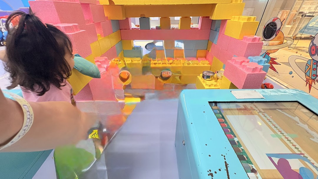 A child plays with colorful oversized building blocks in an interactive Yooland play area.