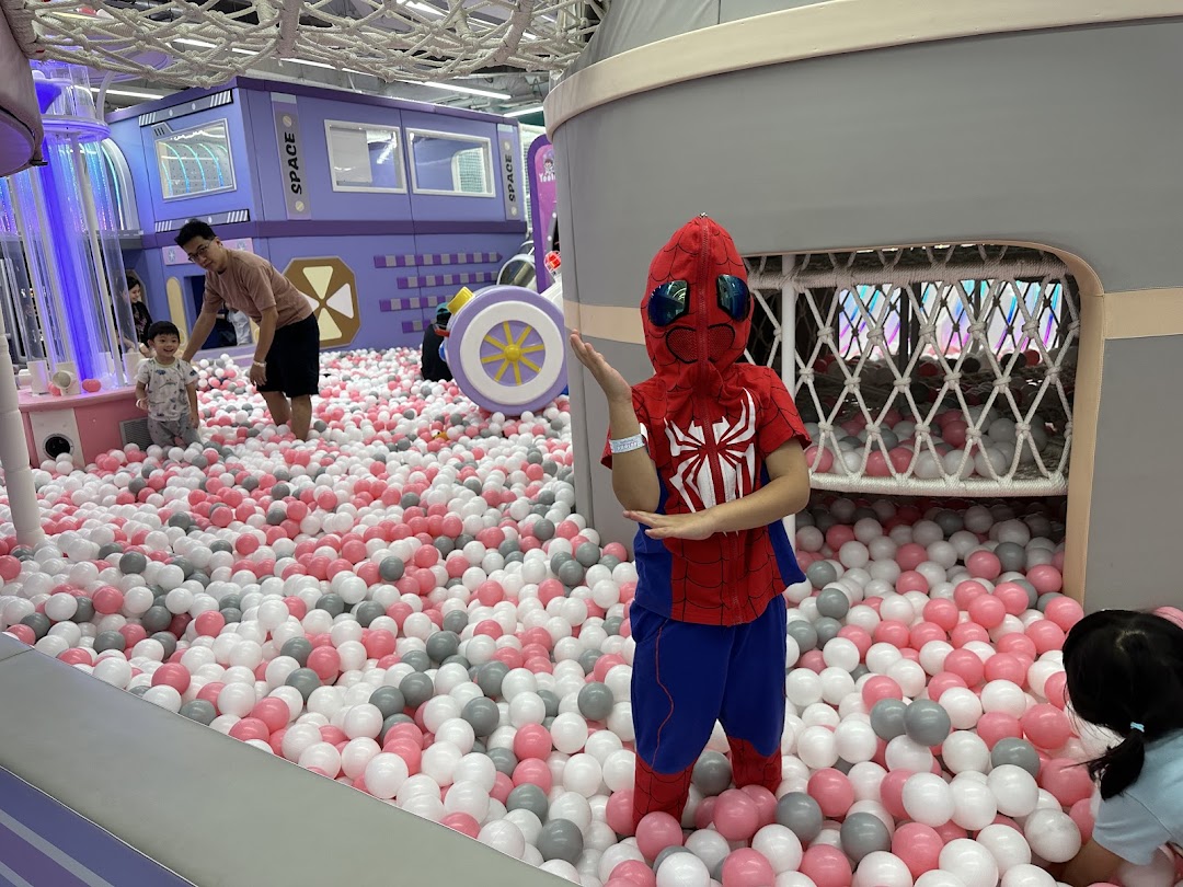 Children and adults enjoy a vibrant ball pit and play structures at Yooland's indoor playground.