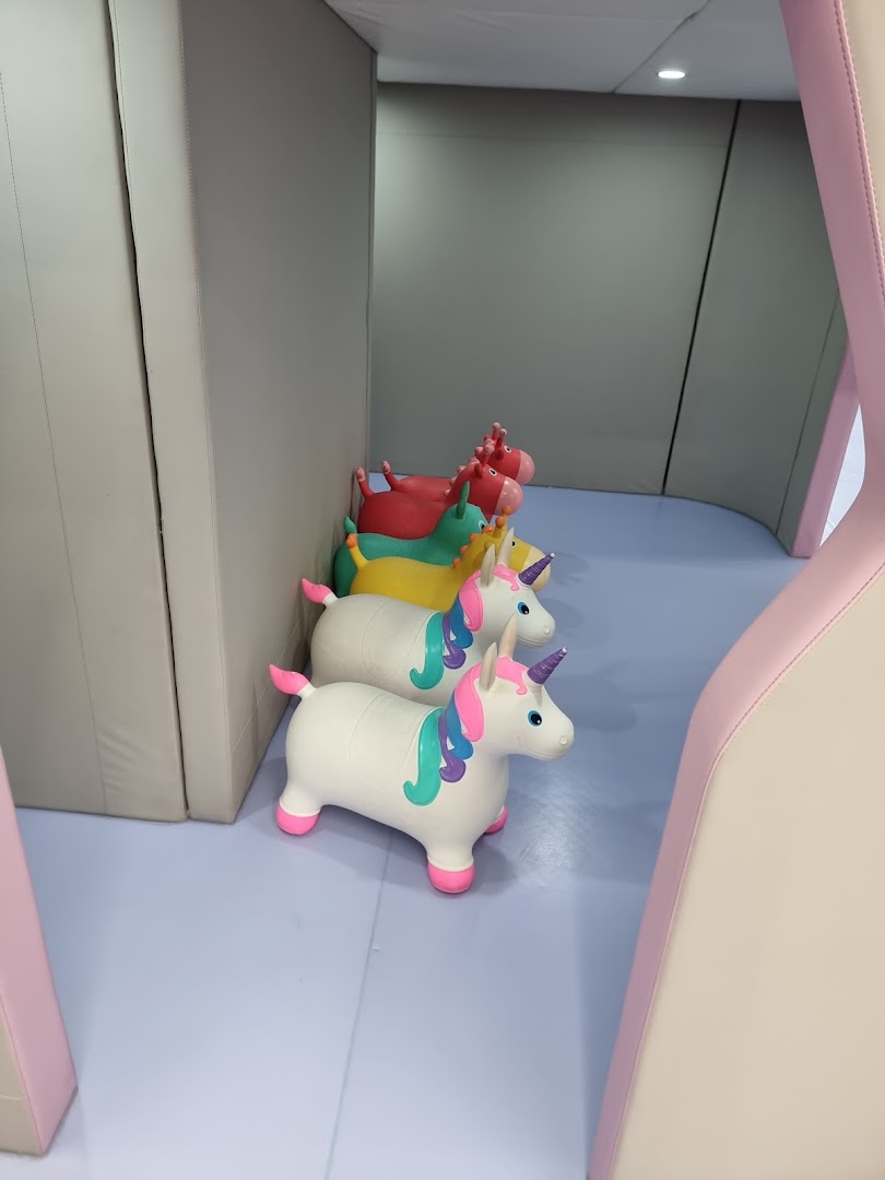 Colorful bouncy unicorn toys lined up in a soft play area at Yooland.