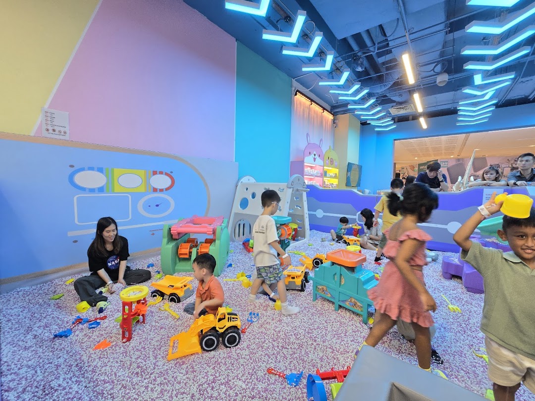 Children and an adult playing with toys in a colorful indoor play area at Yooland.