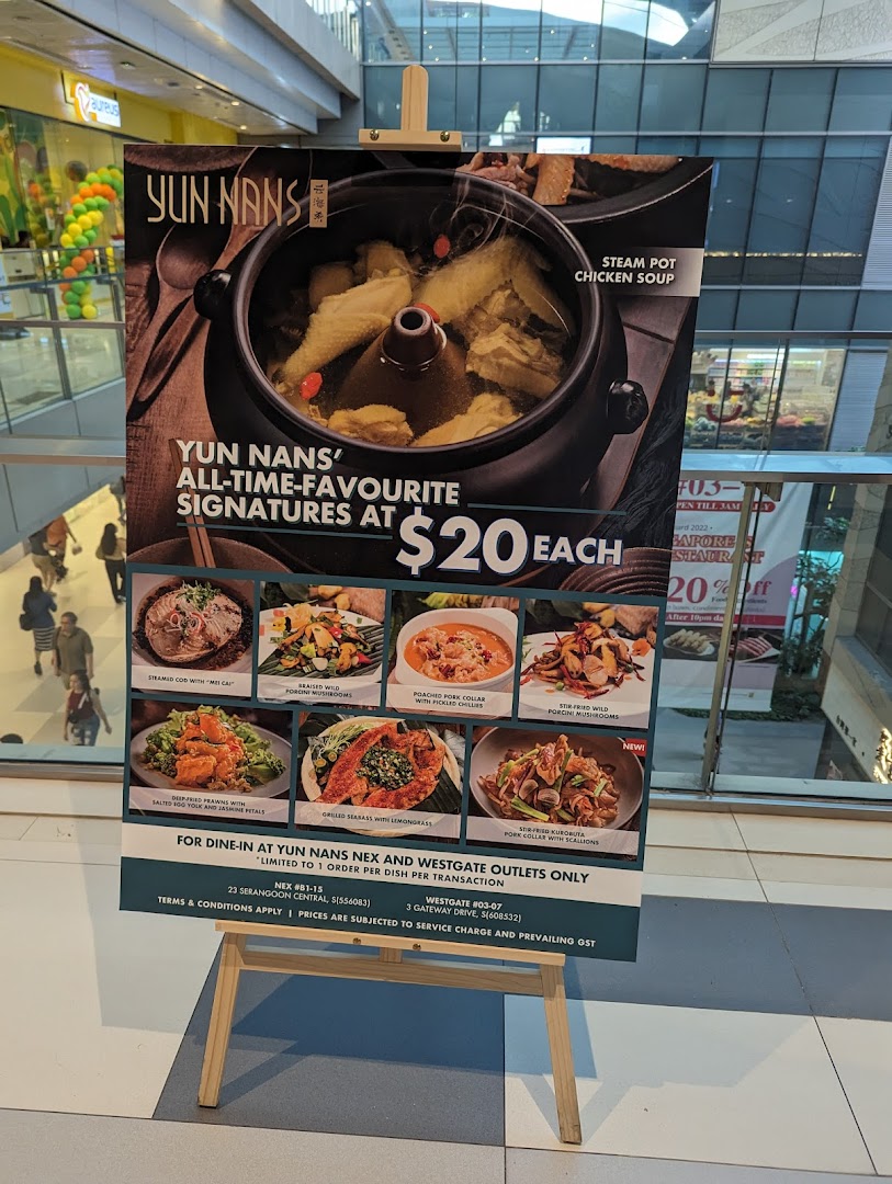 A promotional stand displaying Yun Nans' signature dishes and a special $20 offer.
