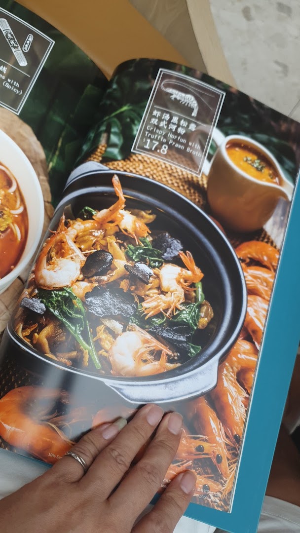 A close-up of a menu page displaying a Crispy Horfun dish with truffle prawn broth.