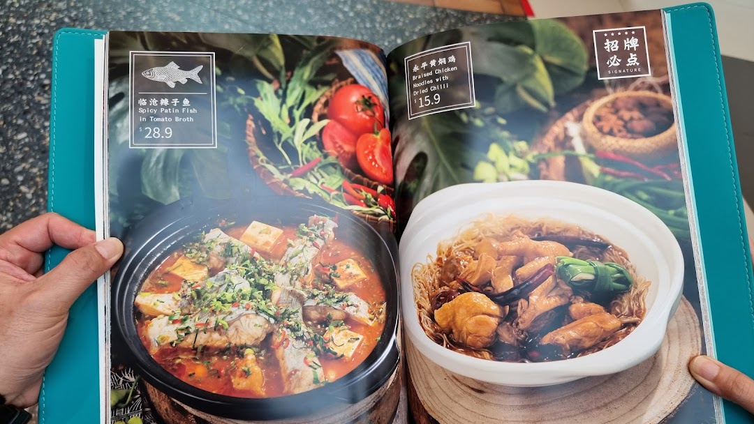 A close-up of a YUN NANS menu displaying two signature dishes with prices.