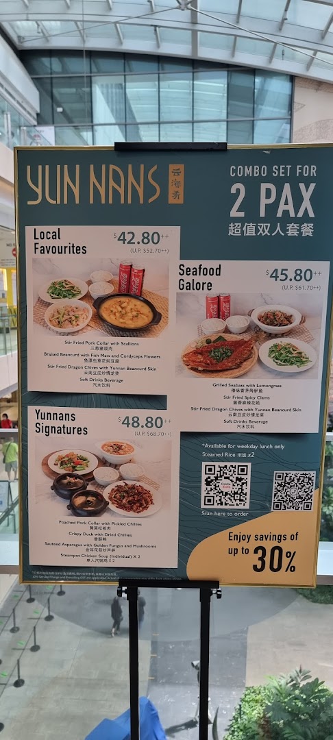 A YUN NANS menu board displaying combo sets for two people with prices and dish details.