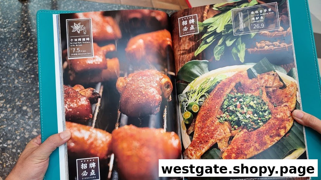 A person holds an open menu displaying YUN NANS' signature grilled pork trotters and grilled seabass.