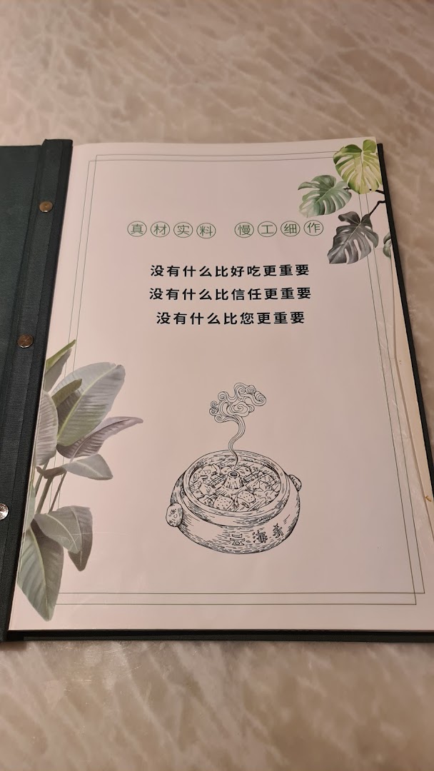 An open menu book page from YUN NANS, featuring the restaurant's philosophy and a hotpot illustration.