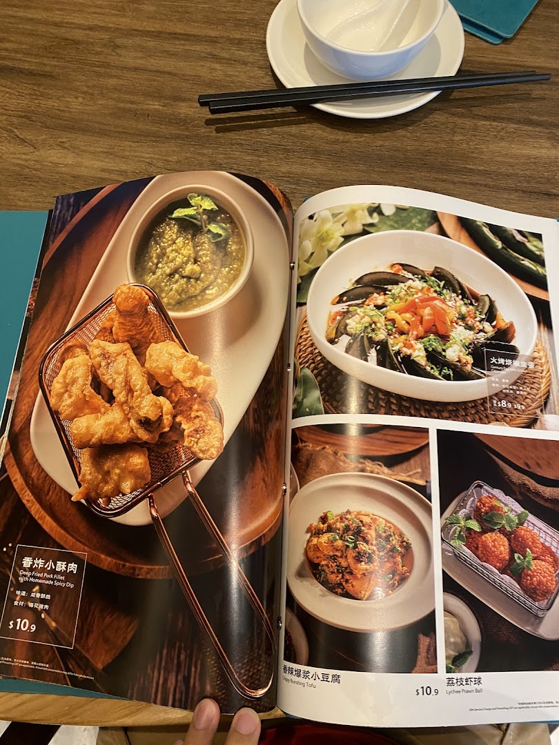 A close-up of a restaurant menu displaying various Chinese dishes with their names, descriptions, and prices.